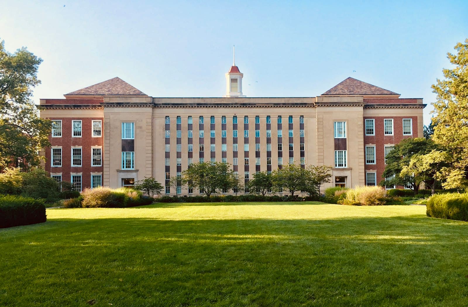 A brick university building across a wide lawn
